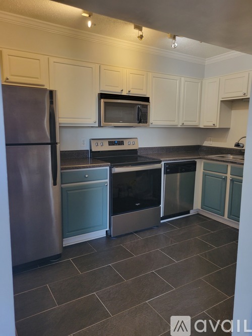 A kitchen with a stainless steel refrigerator, microwave, oven, and cabinets.