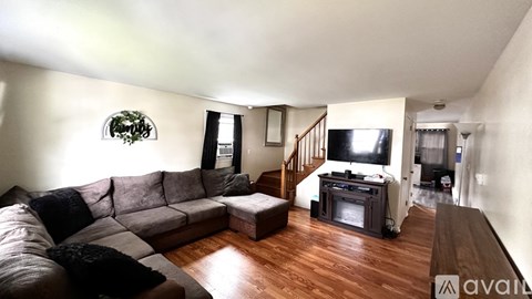 A living room with a grey couch and a wooden floor.