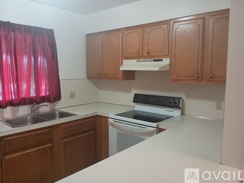 A kitchen with wooden cabinets and a white countertop.