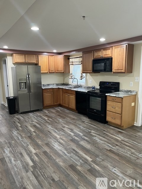 A kitchen with wooden cabinets and a black stove top oven.