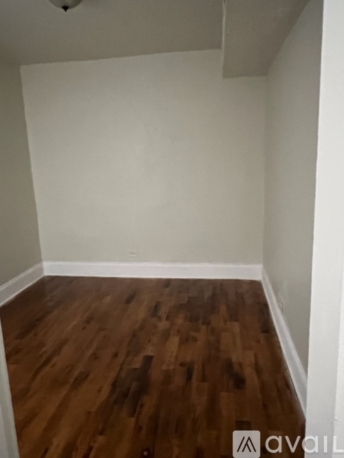 A room with wooden flooring and white walls.