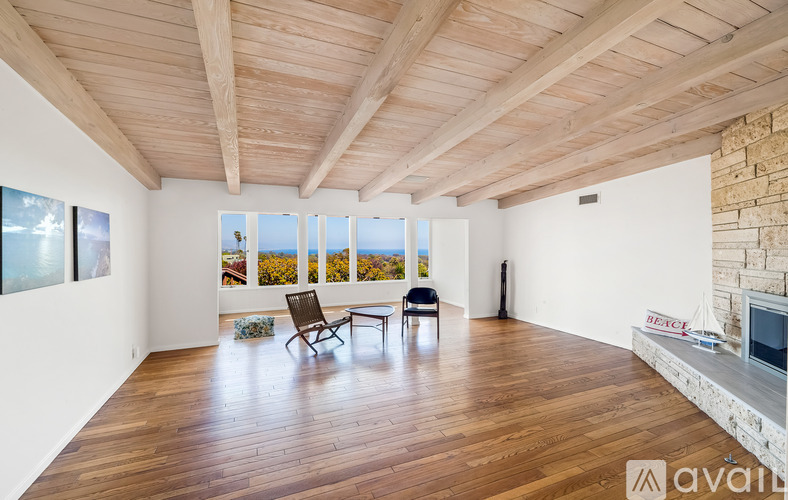 A living room with wooden floors and a stone fireplace.