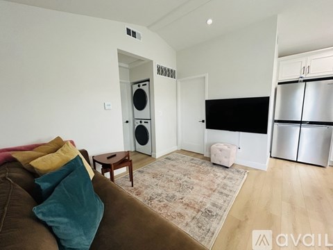 A living room with a brown couch and a rug.