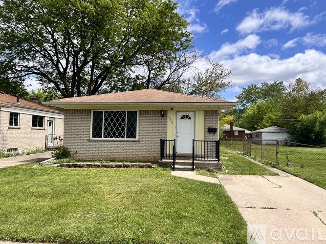 A small house with a white door and a black fence.