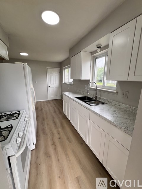 A kitchen with white cabinets and a white gas stove.