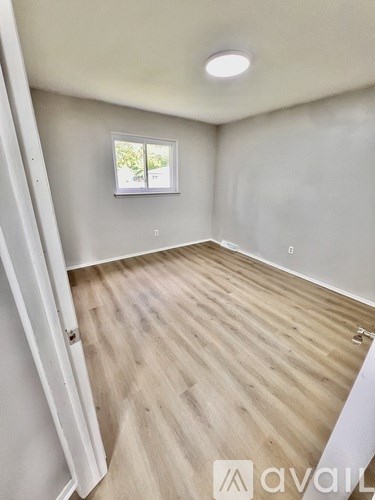 A room with wooden flooring and a window.