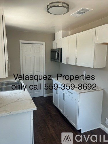 A kitchen with white cabinets and a white door.