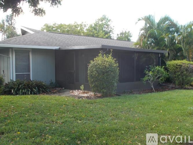 A house with a grey roof and a garden in front.