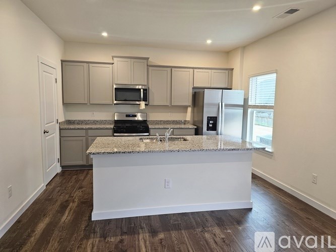 A kitchen with a granite countertop and stainless steel appliances.