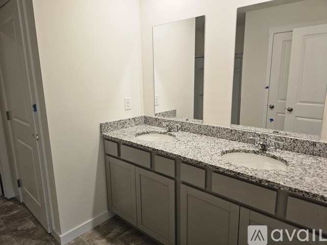 A bathroom with a granite countertop and a large mirror.