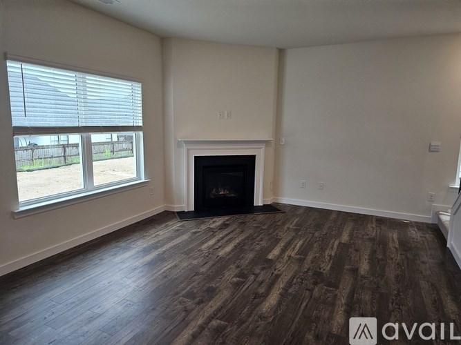 A room with a fireplace and wooden flooring.