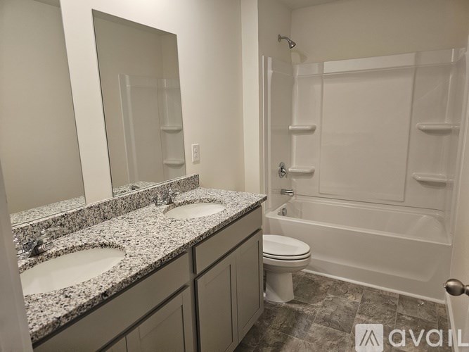 A bathroom with a granite counter top and a walk in shower.