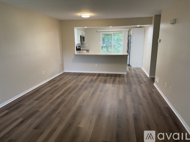 A room with wooden flooring and a window.