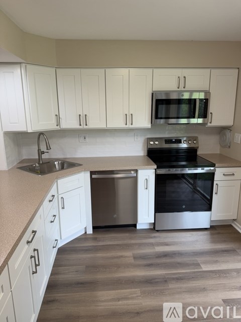 A kitchen with white cabinets and a black oven.