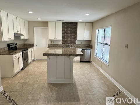 A kitchen with white cabinets and a central island.