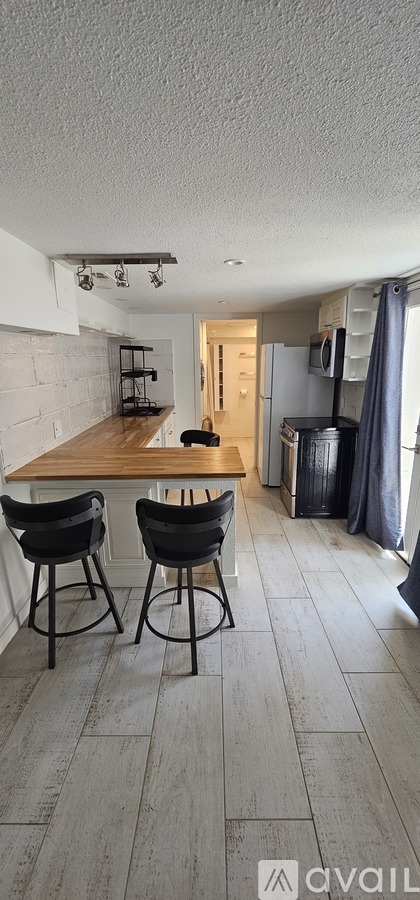 A kitchen with a wooden countertop and bar stools.