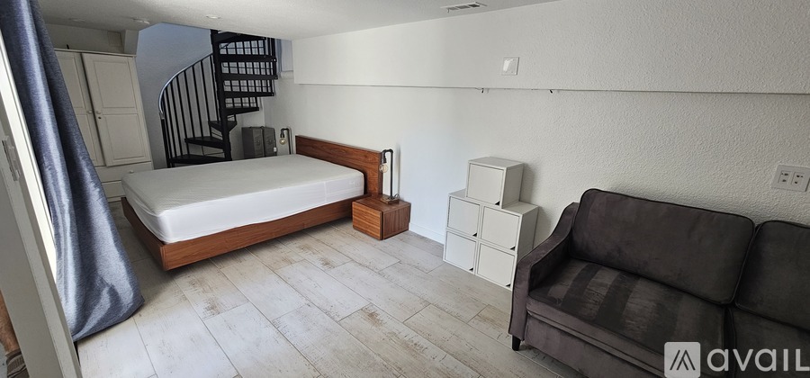 A bedroom with a bed, a couch, and a wardrobe.