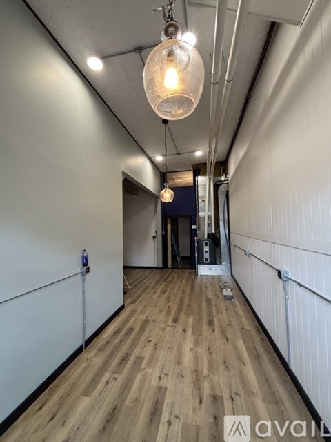 A long hallway with a light bulb hanging from the ceiling.