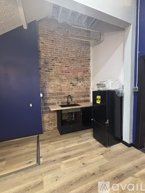 A room with a brick wall and a wooden floor.