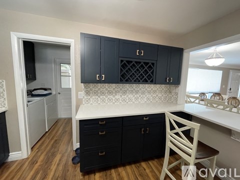 A kitchen with black cabinets and a white countertop.