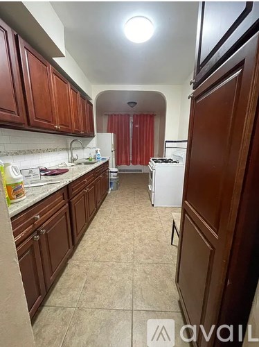 A kitchen with brown cabinets and a white dishwasher.