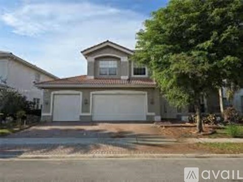 A house with a brown roof and two garages is for sale.