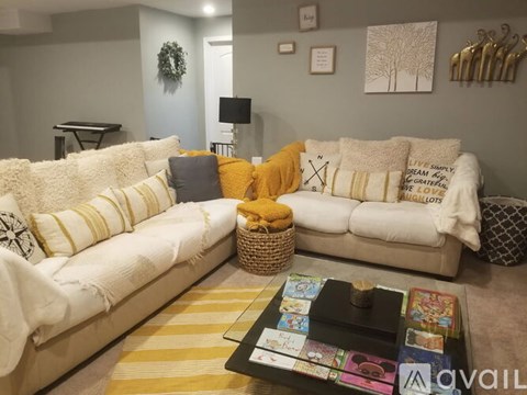 A living room with a white couch and a coffee table with a basket on it.