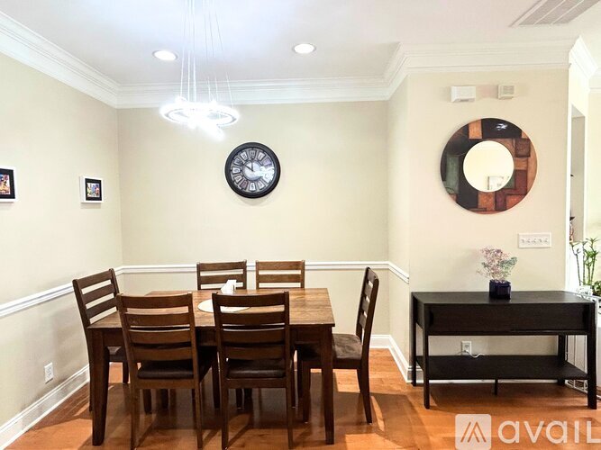 A dining room with a wooden table and chairs.