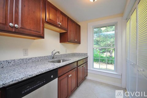 A kitchen with wooden cabinets and granite countertops.