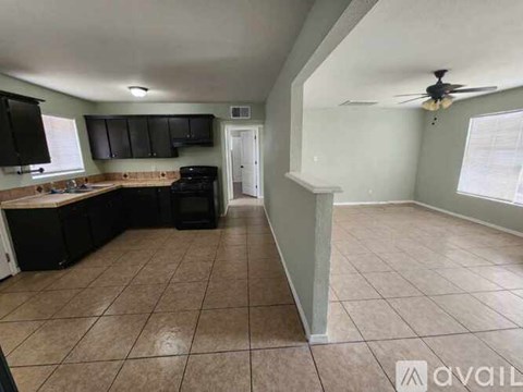 A kitchen with black cabinets and a tiled floor.