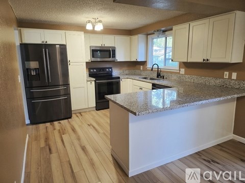 A kitchen with a granite countertop and stainless steel appliances.