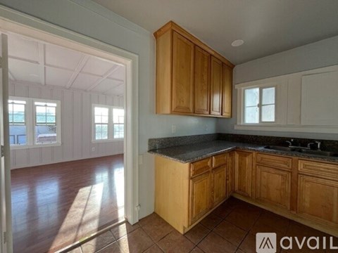 A kitchen with wooden cabinets and a black countertop.
