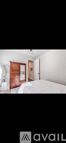A bedroom with a bed, dresser, and mirror.