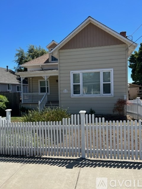 A house with a white picket fence in front.