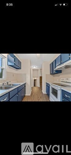 A modern kitchen with blue cabinets and stainless steel appliances.