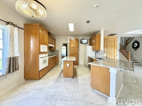 A kitchen with wooden cabinets and a marble countertop.