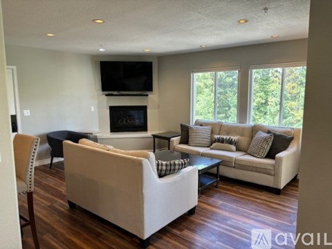 A living room with a fireplace and a television mounted above it.