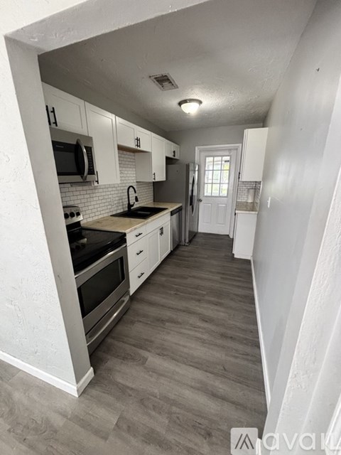 A kitchen with white cabinets and a black stove top oven.