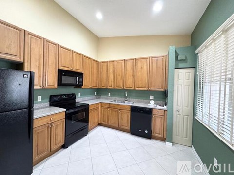 A kitchen with black appliances and wooden cabinets.