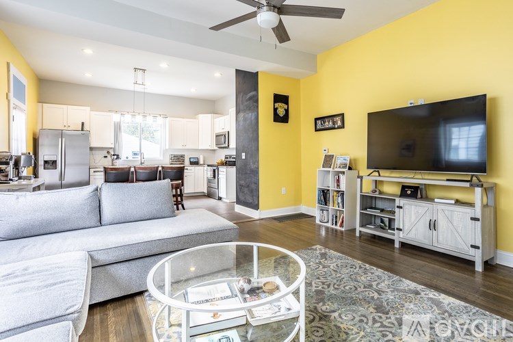 A modern living room with a grey sofa and a glass coffee table.