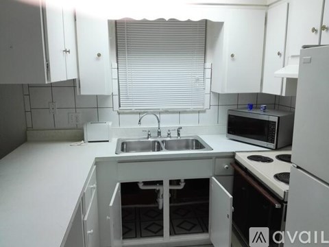 A kitchen with white cabinets and a sink.