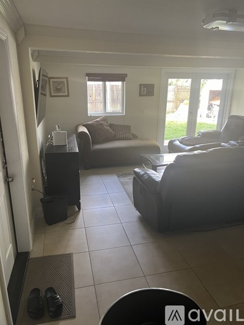 A living room with a couch, chair, and a small table with a radio on it.