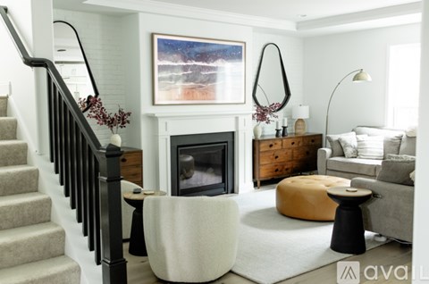 A living room with a fireplace and a painting on the wall.