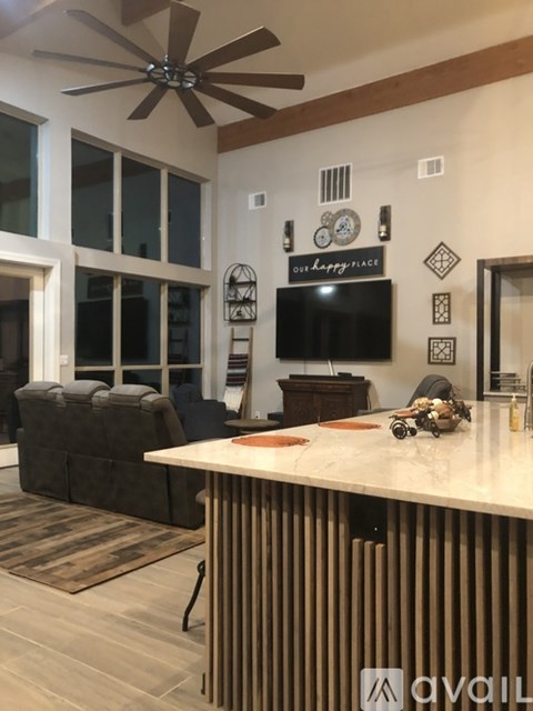 A living room with a brown couch and a white counter.