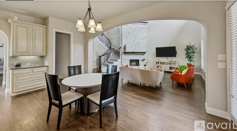 A dining room with a table set for four and a television in the background.