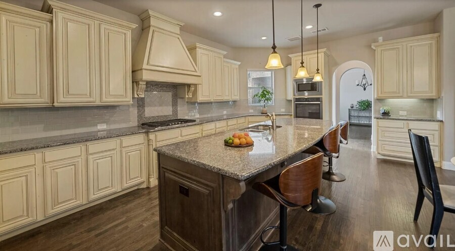 A kitchen with a granite countertop and wooden cabinets.