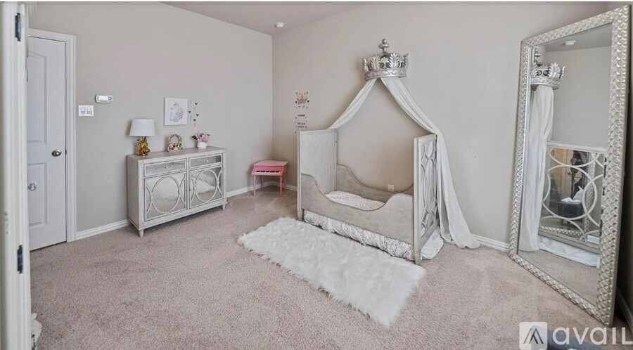 A white bedroom with a canopy bed and a vanity table.