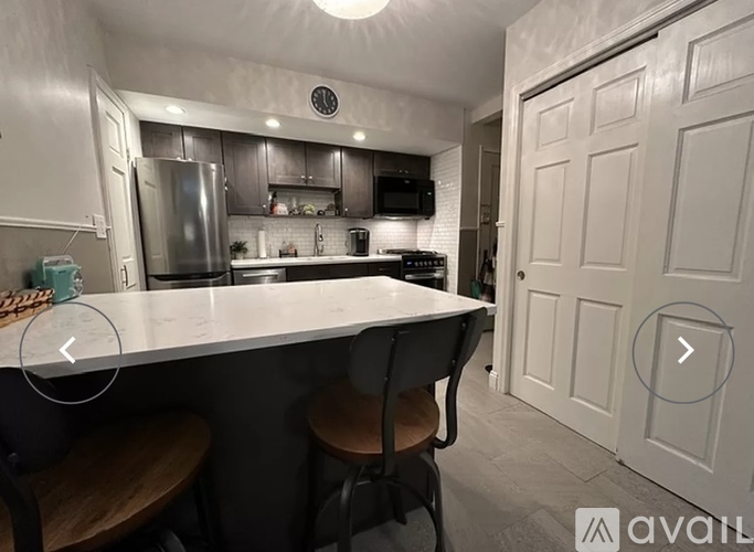A kitchen with a white countertop and a white door.