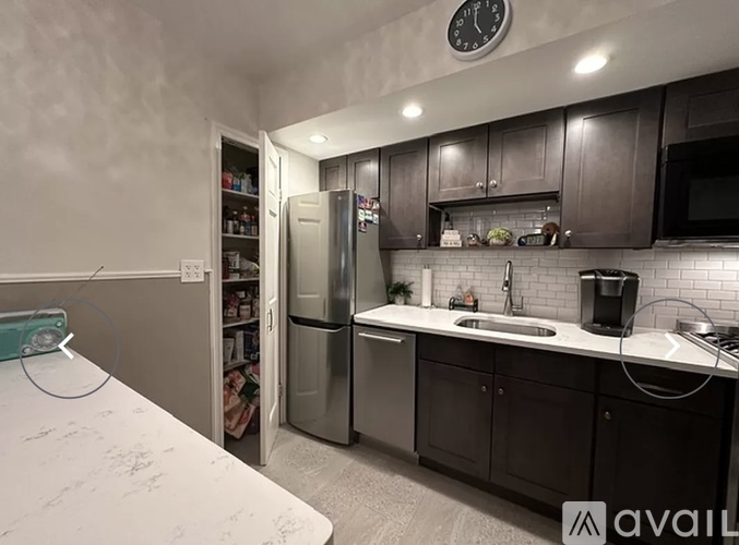 A kitchen with a refrigerator, microwave, and sink.