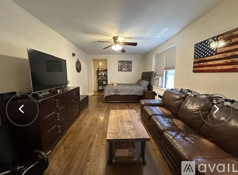 A living room with a brown leather couch and a wooden coffee table.
